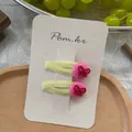 Detailed view of two yellow fabric hair clips with pink dots and red bows on a card - Rose Pink Bowknot Style