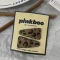 Dettaglio di fermagli triangolari leopardati con cuciture bianche su carta espositiva - Stile Solido Triangolo Chiaro