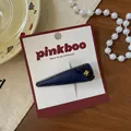 Detail of dark blue leather teardrop hair clip with black bow and gold buckle - Blue