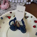 Detail of dark blue knitted cherry hair ties on a cream display card for kids - Blue Pear