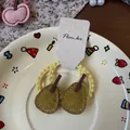 Détail d'élastiques en tissu jaune avec breloque poire verte sur assiette - Poire Jaune
