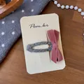 Detailansicht der rosa Samtschleife Haarspange mit grauem Strick-Clip auf Karte - Rosa