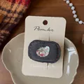 Detail van vintage grijze corduroy haarspeld met bloemenpatch en hartvormige knoop - Grijze Bloemen Lovertjes