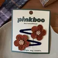 Dettaglio di fermagli per capelli a fiore marrone fatti a mano con perle in piatto ceramico - Stile Fiore Marrone