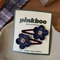 Dettaglio di fermagli per capelli a fiore blu con perline in legno su cartoncino - Stile fiore blu