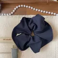 Close-up of navy blue plaid scrunchie with ribbed texture on a decorative setup - Blue Solid Scrunchie