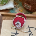 Détail d'une pochette brodée lapin rouge faite main avec dentelle sur fond de bois naturel - Lapin Fraise
