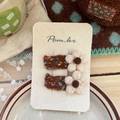Detailed view of handmade brown wool flower hair clips on a branded display card - Brown Woolen Flower Hair Clip
