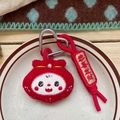 Detailed macro view of a red plush lucky bag keychain with a golden pearl and embroidery - Blessing Lucky Bag Style