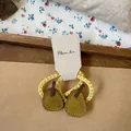 Detail view of pear-shaped felt hair tie with yellow elastic on a rustic fabric background - Yellow Pear Hair Tie