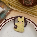 Détail d'un chouchou en tissu lapin jaune avec broderie Coffee sur une assiette - Animal Jaune (NK1705)
