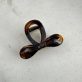 Detail view of bow-shaped hair claw clip in tortoiseshell resin with a glossy finish - Glossy Yellow Coffee
