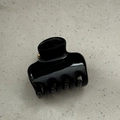 Close-up of a glossy black hair claw clip with golden metal spring on a stone surface - Square Bone Style / 5cm / Bright Black