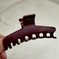 Detail view of burgundy glossy hair claw clip with golden spring on stone texture - 11.5cm Beveled Spine Style