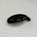 Detail view of the polished black banana hair clip with elegant gold Barrette lettering - Large / Bright Black