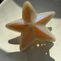 Makroaufnahme der sternförmigen Haarklammer mit orange-perlmuttfarbenem Muster - Beiger Stern mit Silberschimmer