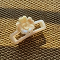 Detail view of pearl-white resin hair claw clip with floral pattern on woven texture - Rectangular Claw Clip / Beige