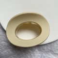 Detail van ovale mat beige haarklem met interne grip tanden op een grijze achtergrond - Ovale Stijl (o型抓夹)