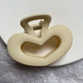 Detail of a matte cream hollow heart hair claw clip on a minimalist textured background - Hollow Heart Claw Clip
