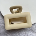 Detailed macro of a matte cream rectangular hair claw clip with metal spring mechanism - Rectangular Hollowed-out Style (Rectangular Claw Clip)
