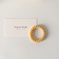 Pastel yellow spiral phone cord hair tie with flexible resin and minimalist design - Yellow