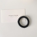 Elastic black spiral hair tie in sleek resin material for minimalist ponytail styling - Black