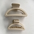 Detail view of two matte cream hair claws in different sizes for versatile styling - Small Half-round / Off White
