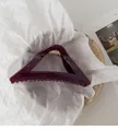 Detail view of burgundy triangular shark clip on minimalist white artistic paper - Dark Purple