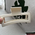 Gros plan sur une pince à cheveux rectangulaire blanc crème avec dents antidérapantes et ressort - Blanc Cassé