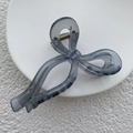 Translucent gray bow hair claw clip made of resin for elegant updos on a white plate - Transparent Gray
