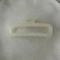 Close-up of minimalist rectangular hair claw clip in creamy white translucent finish - Jelly White