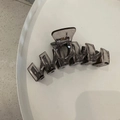 Détail d'une grande pince à cheveux translucide gris foncé de 13cm avec ressort en métal - Série Gris Épissage