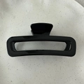 Macro view of large rectangular hollow hair claw clip in glossy black minimalist design - Bright Black