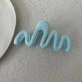 Dettaglio macro di un mollettone per capelli ondulato azzurro 13 cm su base in pietra - Azzurro