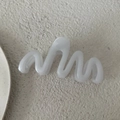 Dettaglio ravvicinato di una pinza per capelli bianca da 13cm con design a onda opaca - Bianco Gelatina