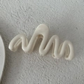 Dettaglio macro di un fermaglio per capelli ondulato da 13 cm crema su pietra ruvida - Bianco Solido