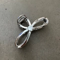 Detailed top view of a polished silver geometric hair claw clip on a gray background - Large Bowknot (13cm) / Silver