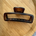Detail view of large 12cm tortoiseshell hair claw clip with rectangular cutout on wood tray - Matte Yellow Coffee Tortoise
