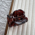 Detailed view of translucent amber flower resin hair claw clip in a cream storage tray - Red Tortoiseshell