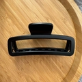 Detail of 12cm black matte rectangular hair claw clip with non-slip teeth on wood tray - Black