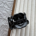 Macro detail of the glossy black camellia flower hair claw clip with a strong metal spring - Bright Black