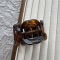 Detailed macro view of an amber resin rose hair claw clip with a bronze spring - Yellow Tortoiseshell