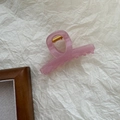 Vista detallada de pinza para el pelo rosa translúcida con resorte dorado - Rosa