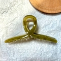 Detail of an olive green jelly-colored hair claw clip with golden metal spring - Jelly Green