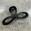 Macro shot of large black glossy hollow hair claw clip with metallic spring mechanism - Bright Black