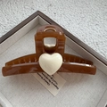 Detalle de pinza para el pelo ámbar con corazón blanco en una bandeja vintage - café