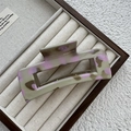 Détail d'une pince à cheveux en acétate gris et rose dans un coffret de présentation - Style Grand Carré