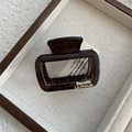 Close-up of translucent dark brown square hair claw clip with gold lettering - Dark Tea Gray Large Arch Claw (Style B)