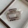 Macro view of a brown translucent resin square claw clip with gold cursive lettering - Transparent Gray Large Arch Claw (Style B)