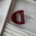 Deep red D-shaped hair claw clip with glossy finish resting in a luxury display box - Hollow Semi-Circle Style / Burgundy